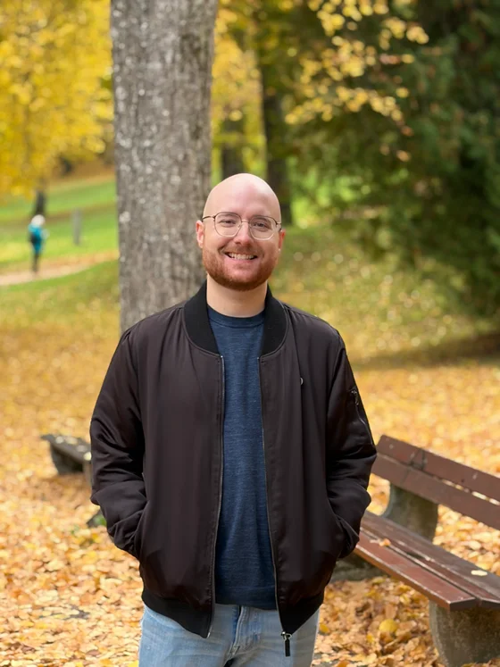 Rob Gilbert, smiling, photographed outdoors among autumn foliage